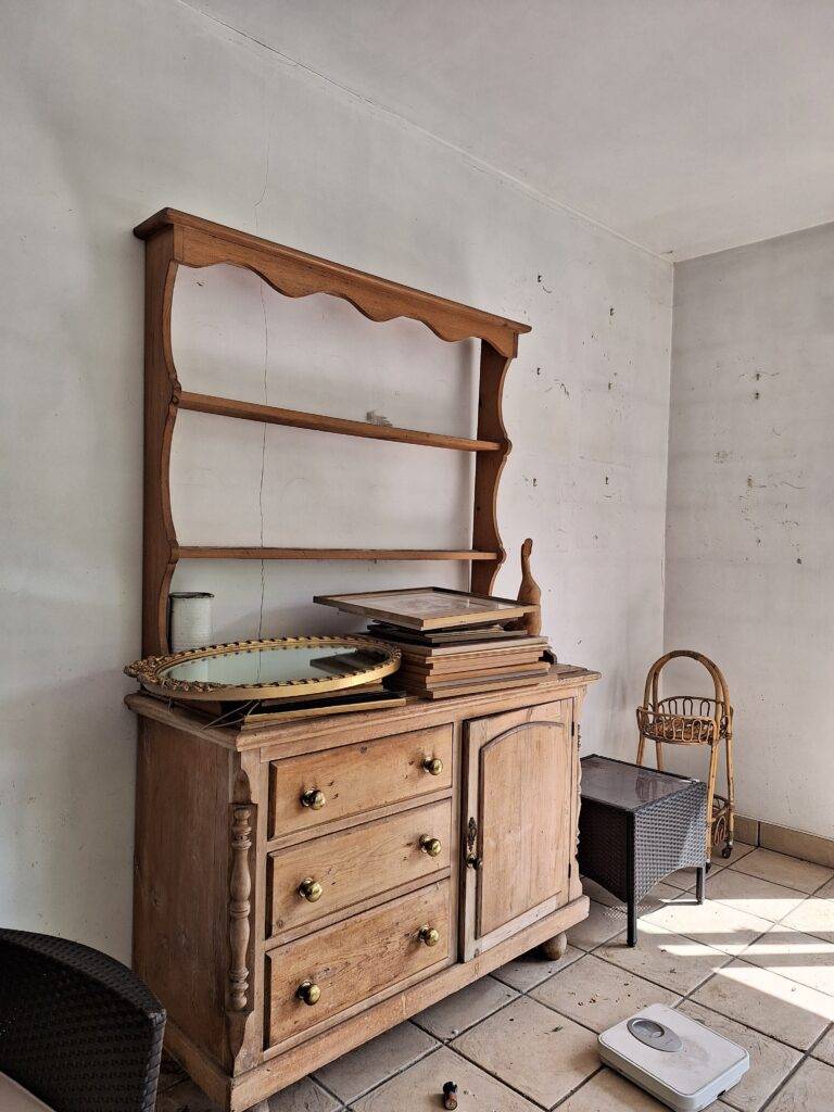 Pictures, ceramics stacked on Welsh dresser. Items ready for removal from Streetly home.