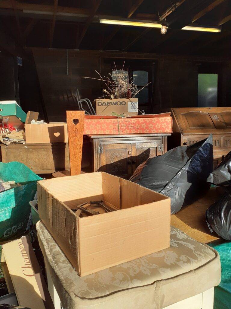 A garage clearance at a home in Birmingham.  Furniture, household items and other rubbish and waste have been sorted and boxed. Items ready for are ready for removal from property, recycling or disposal.